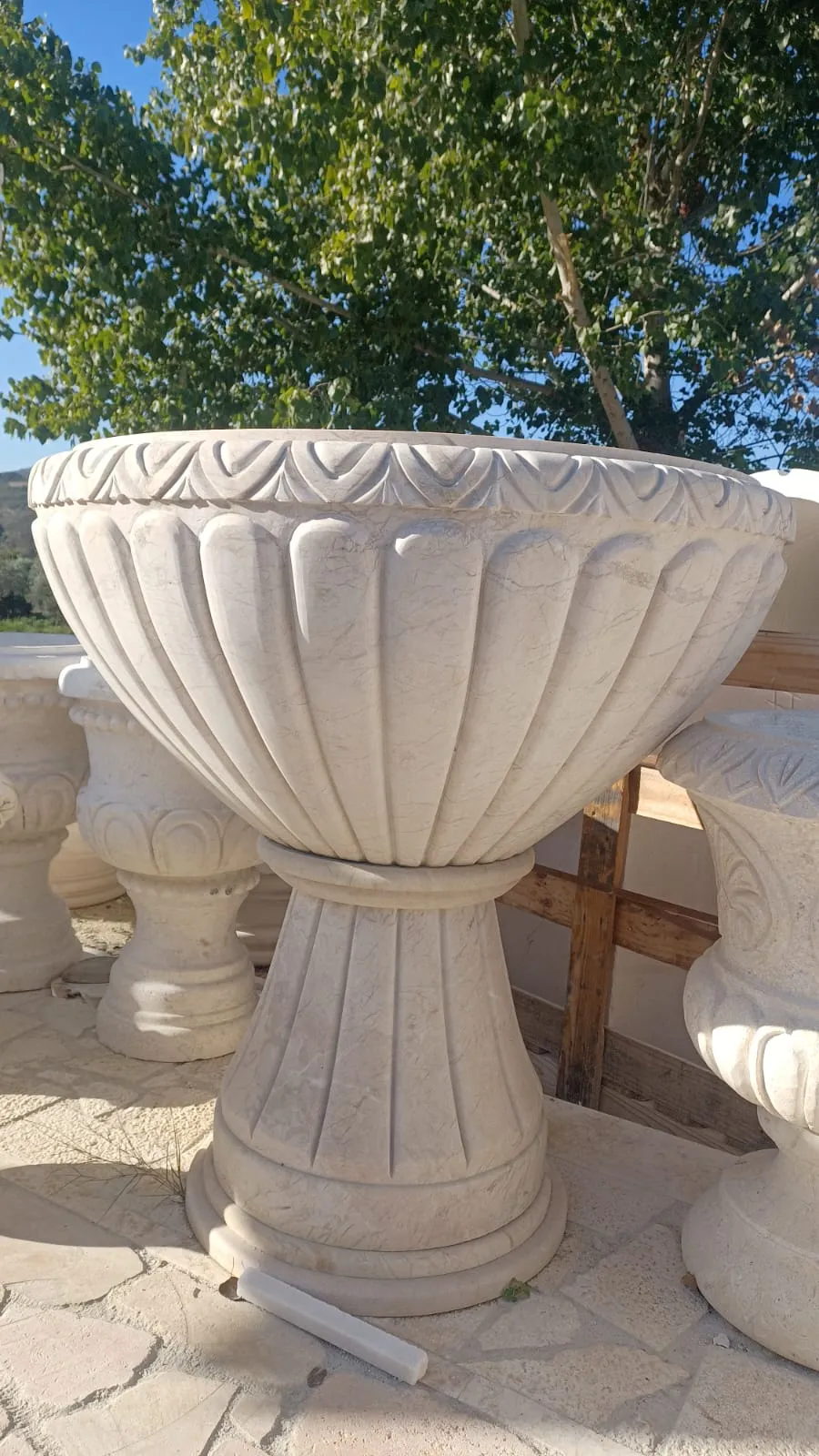 Large carved stone planter with a fluted body